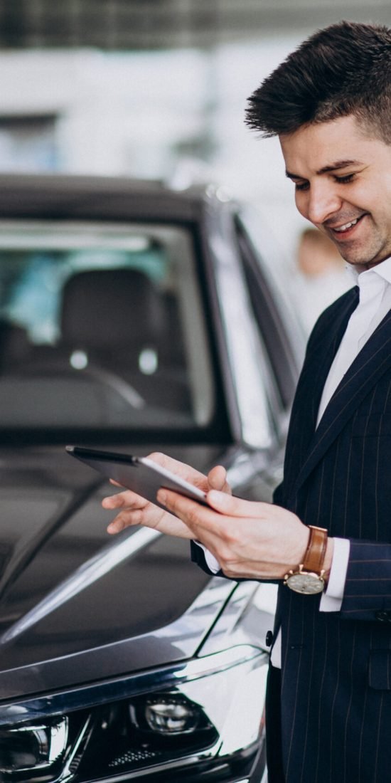 young handsome business man in a car showrrom